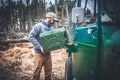 Man loading an olive drab Wavian 20L jerry can onto the side mount of a Toyota FJ40
